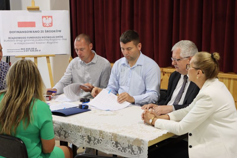Na zdjęciu strony podpisują umowę siedząc przy stole